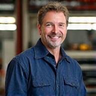 Photo de Jean-Luc Favre le fondateur, souriant dans son atelier.