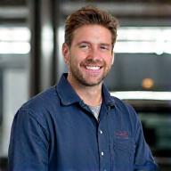Photo de Marc ajustant un échappement dans le garage.